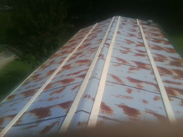 Rusted metal roof panels with new wood purlins before replacement — Storm Damage Roof Repair in Littleton by Roofing Brothers